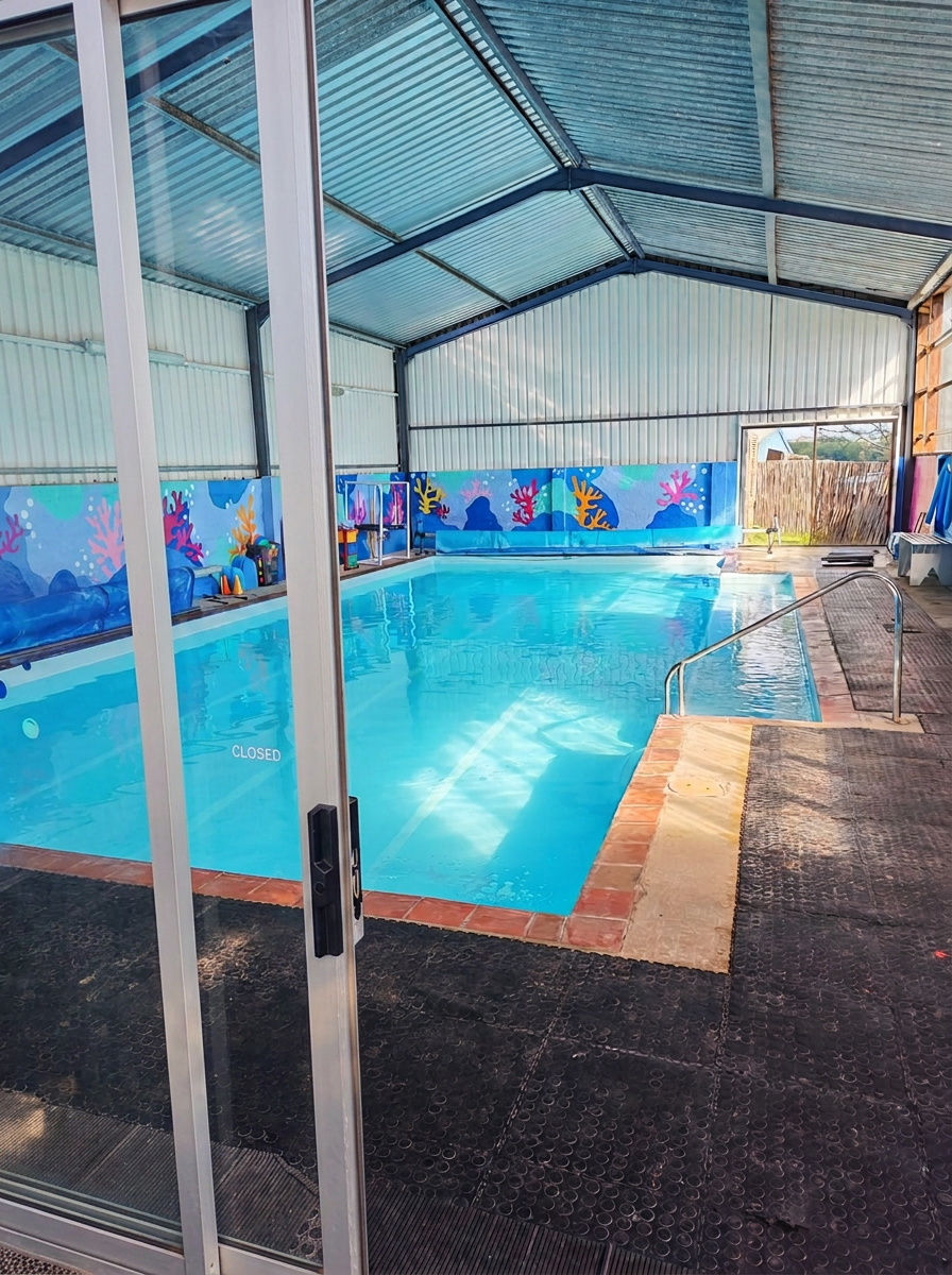The bright heated indoor pool with its colourful coral mural wall